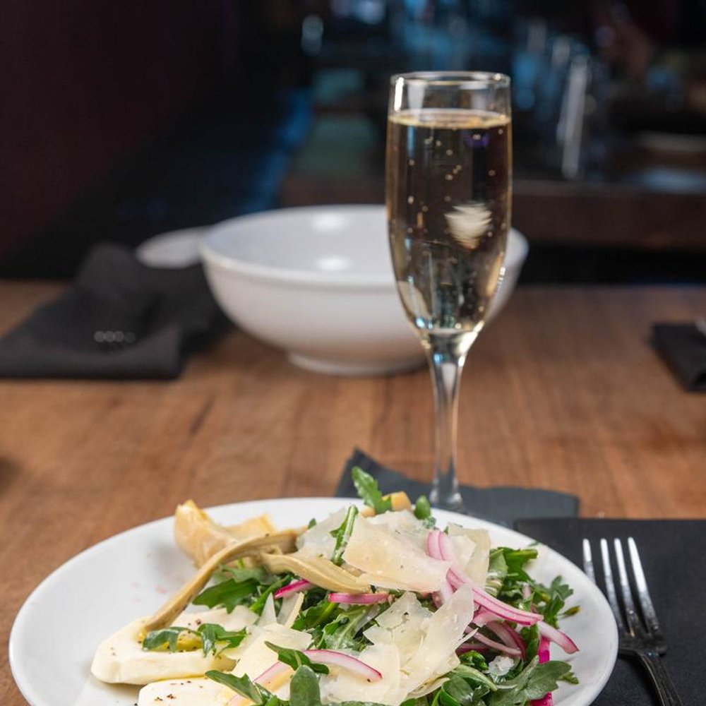 Artichoke Salad Served With Sparkling Wine Empty Bowl In The Background.