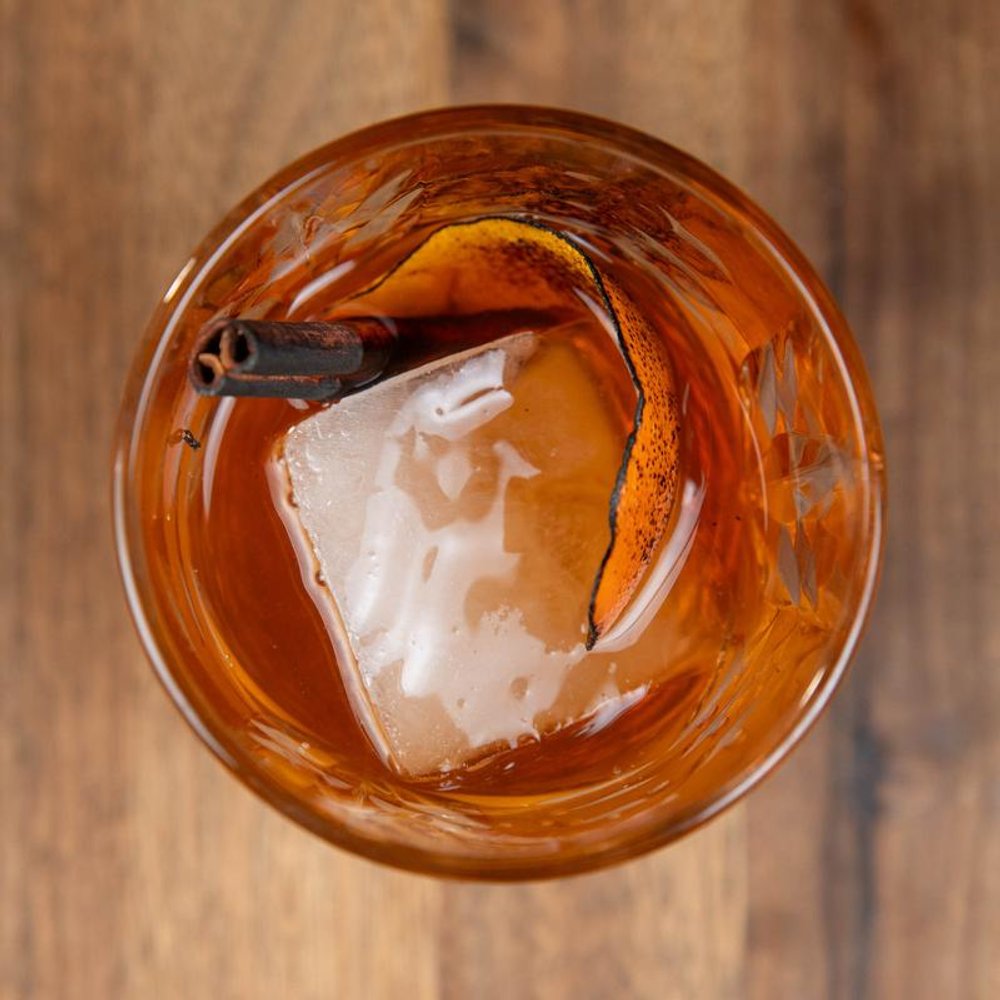Bulleit Proof Cocktail On The Rocks With One Ice Cube And A Burnt Orange Peel.