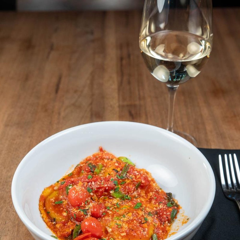 Burrata Ravioli Served With A Glass Of White Wine.