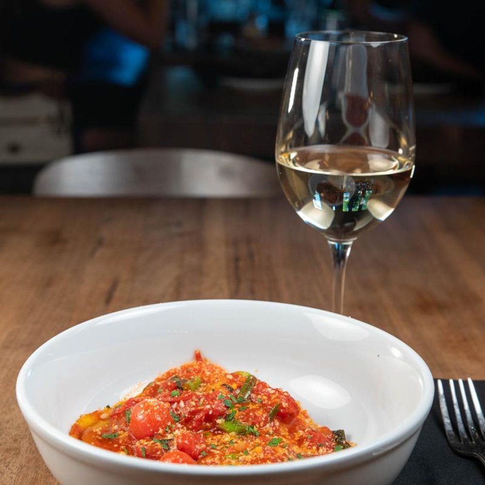Burrata Ravioli With A Glass Of White Wine On A Table.