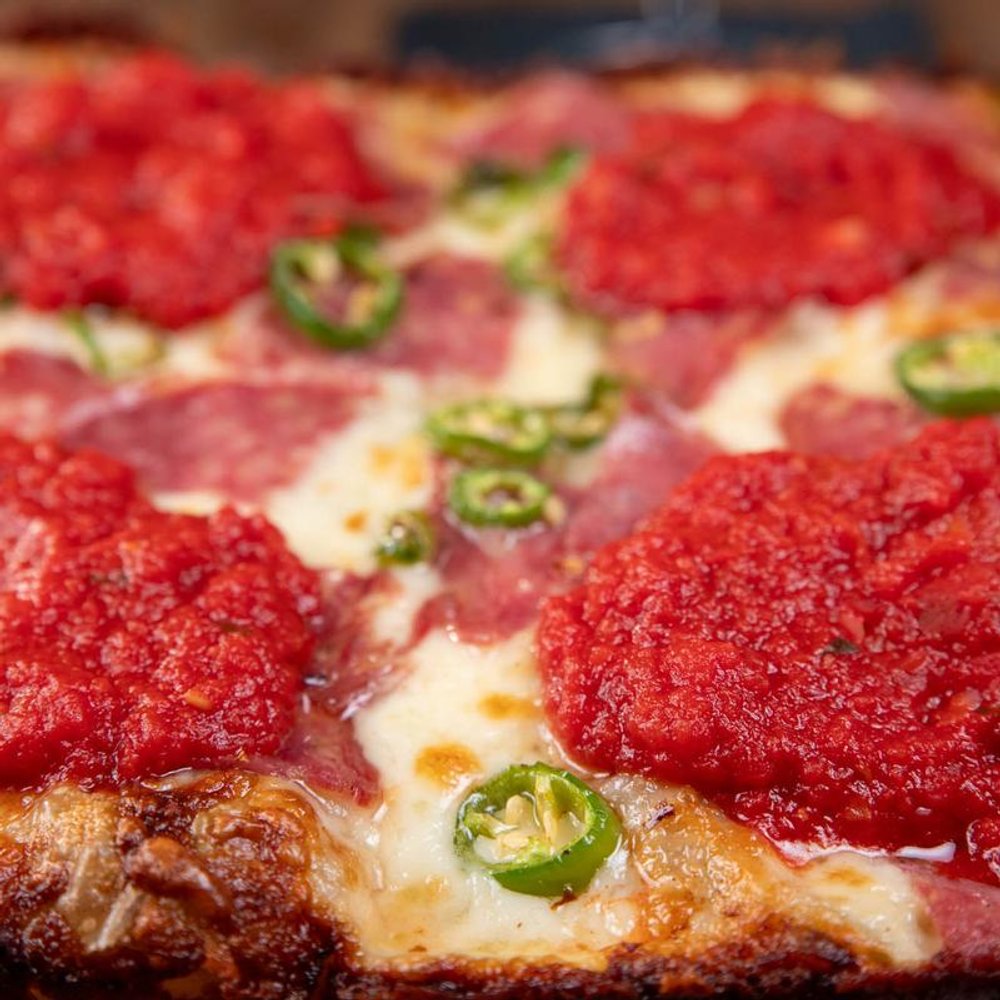 Close Up Of A Soppressata Pizza With Tomato Basil Sauce And Serrano Peppers.