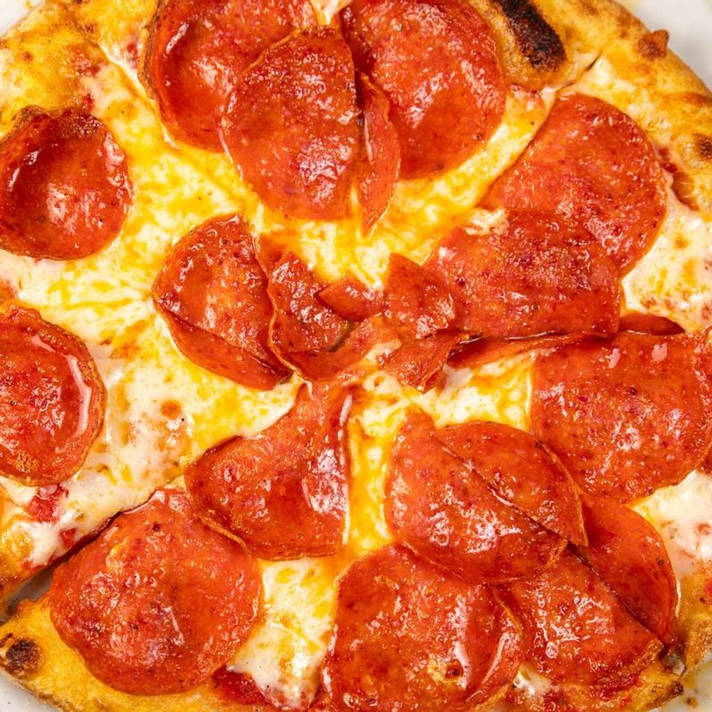 Close Up Pf A Pizza Topped With Red Sauce And Pepperoni.