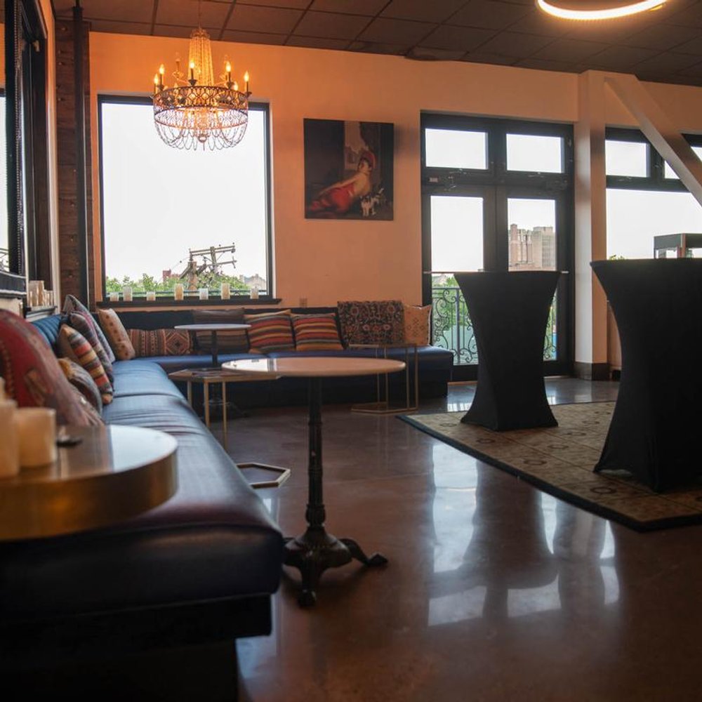 Corner Lounge With A Chandelier Windows Tables And Wall Art.