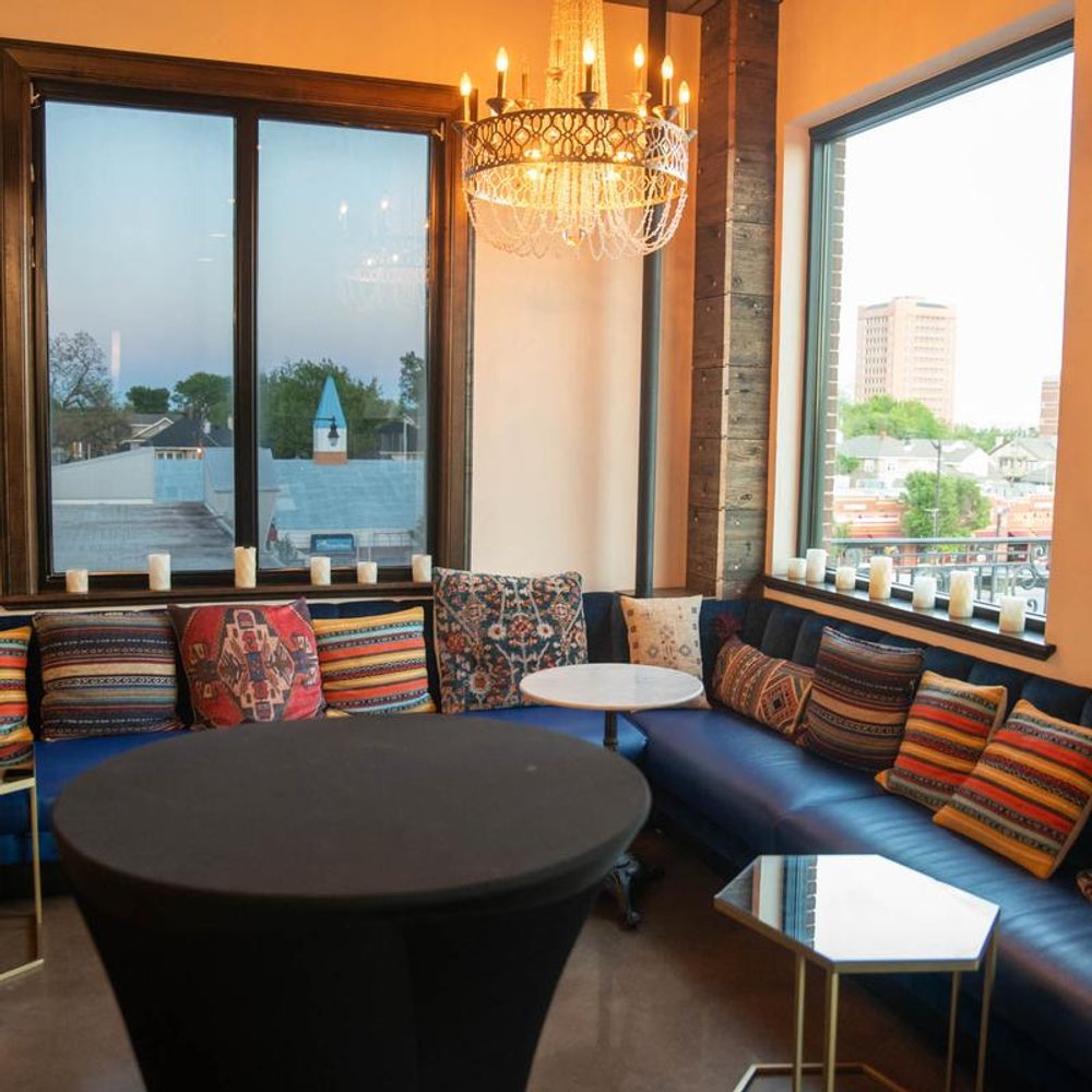 Corner Seating Area By The Windows With A Chandelier Benches And Pillows.