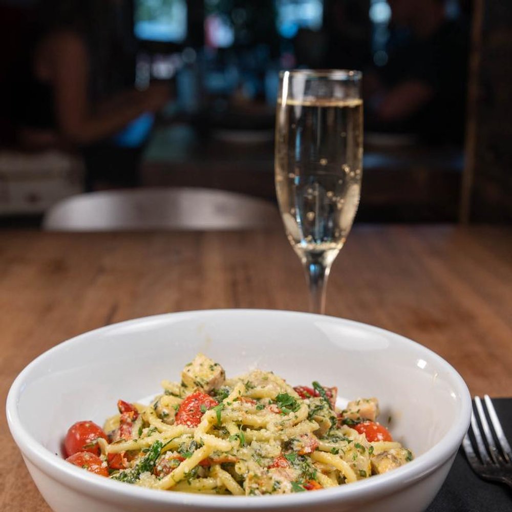 Fettuccine Alfredo On A Table With A Glass Of Sparkling Wine.