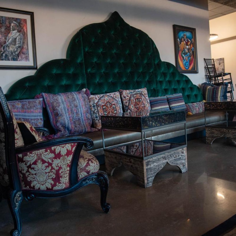 Interior With A Green Couch With Pillows Wall Art And An Ornate Armchair.