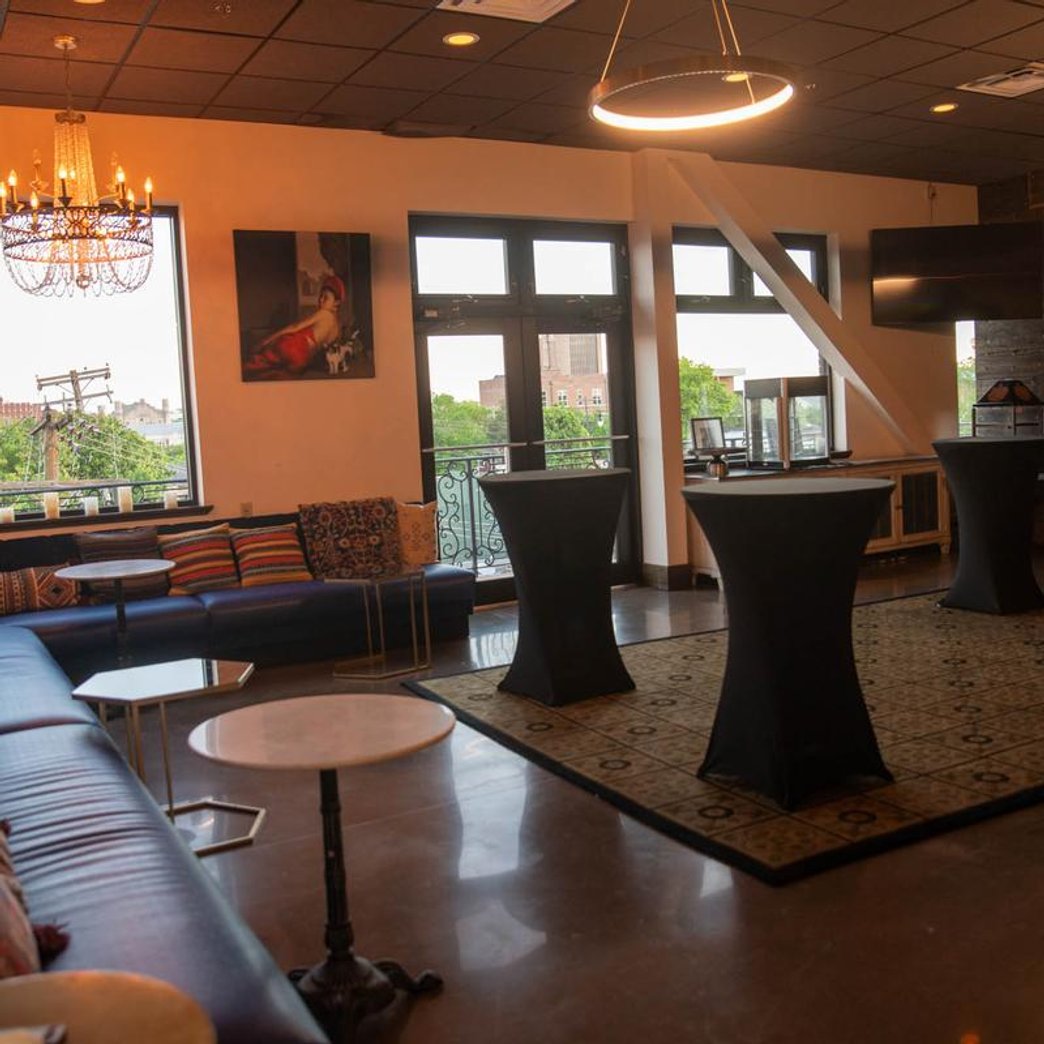 Lounge area with sofas cocktail tables chandeliers and large windows