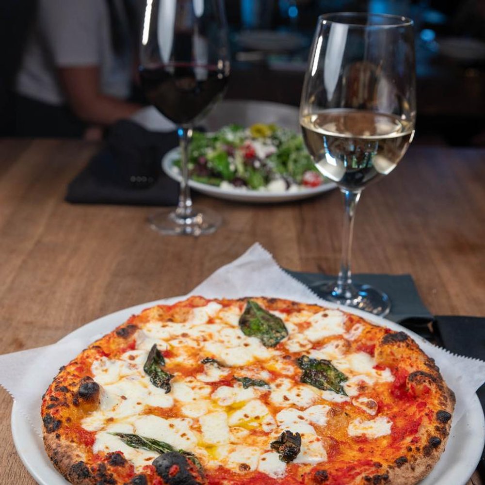 Margherita Pizza With Glasses Of Red And White Wine And A Salad In The Background.