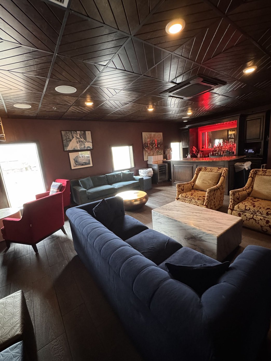 Lounge area with a bar sofas guests and TVs