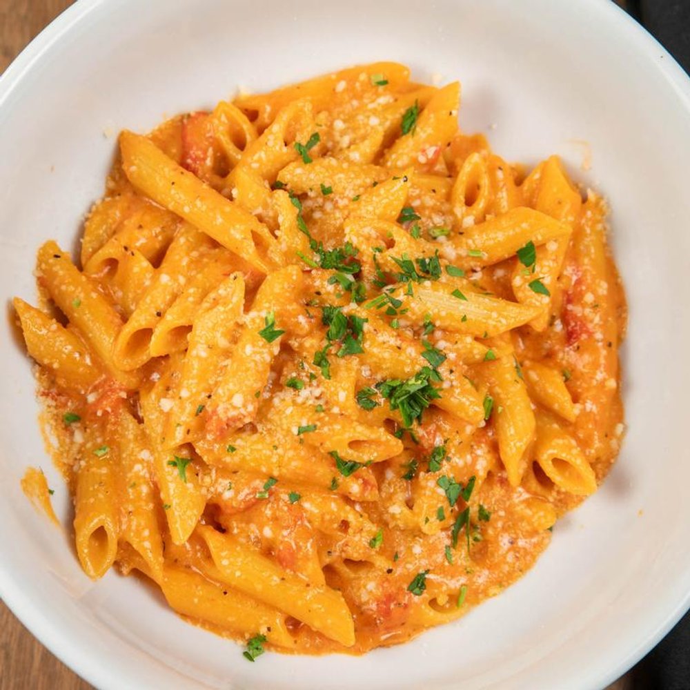 Penne Vodka Pasta Topped With Parmesan And Herbs.