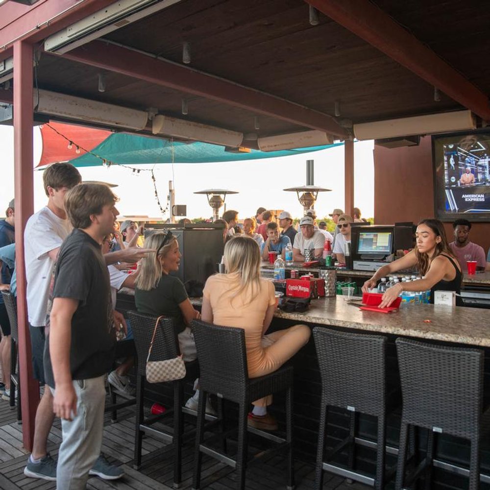 People Socializing Over Drinks At An Outdoor Bar.