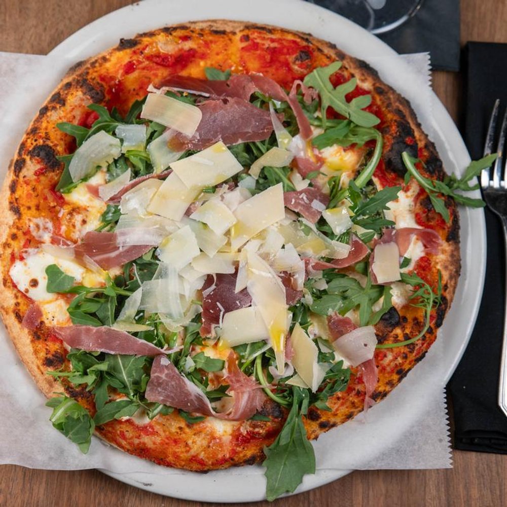 Prosciutto Pizza With Arugula Mozzarella Red Sauce Shaved Parmesan And Basil.