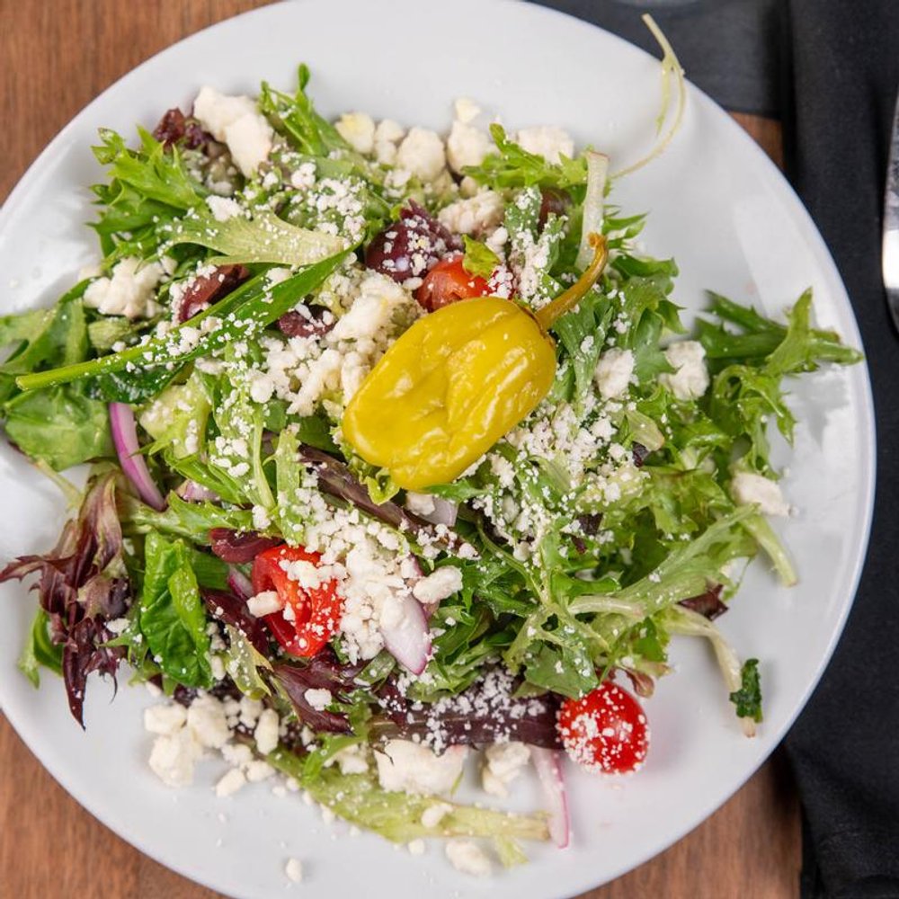 Salad With Greens Tomatoes Crumbled Feta Kalamata Olives And Onions.