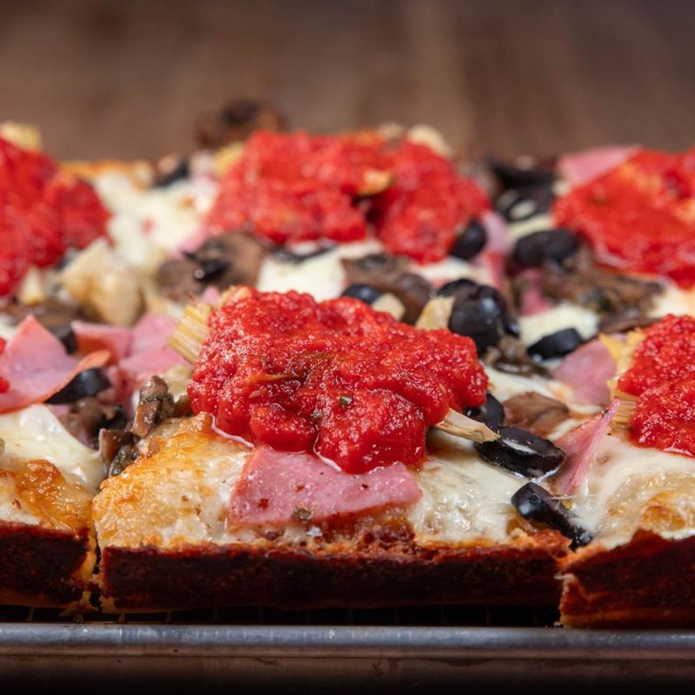 Sliced Detroit Style Pizza With Cheese Tomato Sauce Ham And Olives.