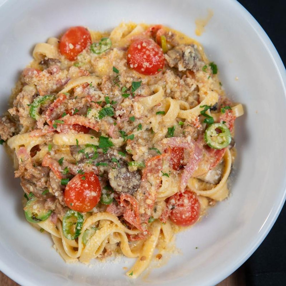 Spicy Fettuccine Pasta With Sausage Pepperoni Tomatoes Parmesan And Serrano Peppers.