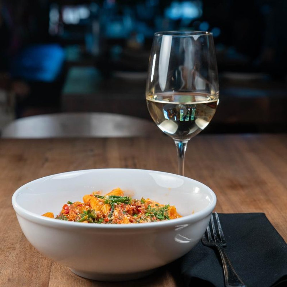 Spicy Rigatoni And A Glass Of White Wine On A Table.