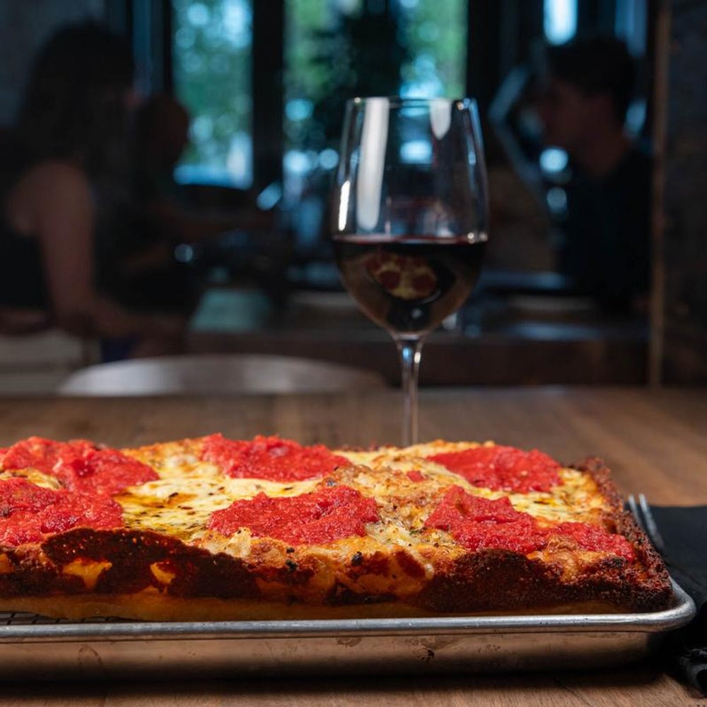 Square Cheese Pizza With Tomato Basil Sauce And Oregano On A Table With Red Wine.
