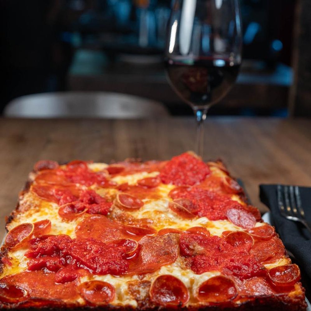 Square Pepperoni Pizza On A Table Next A Glass Of Red Wine.
