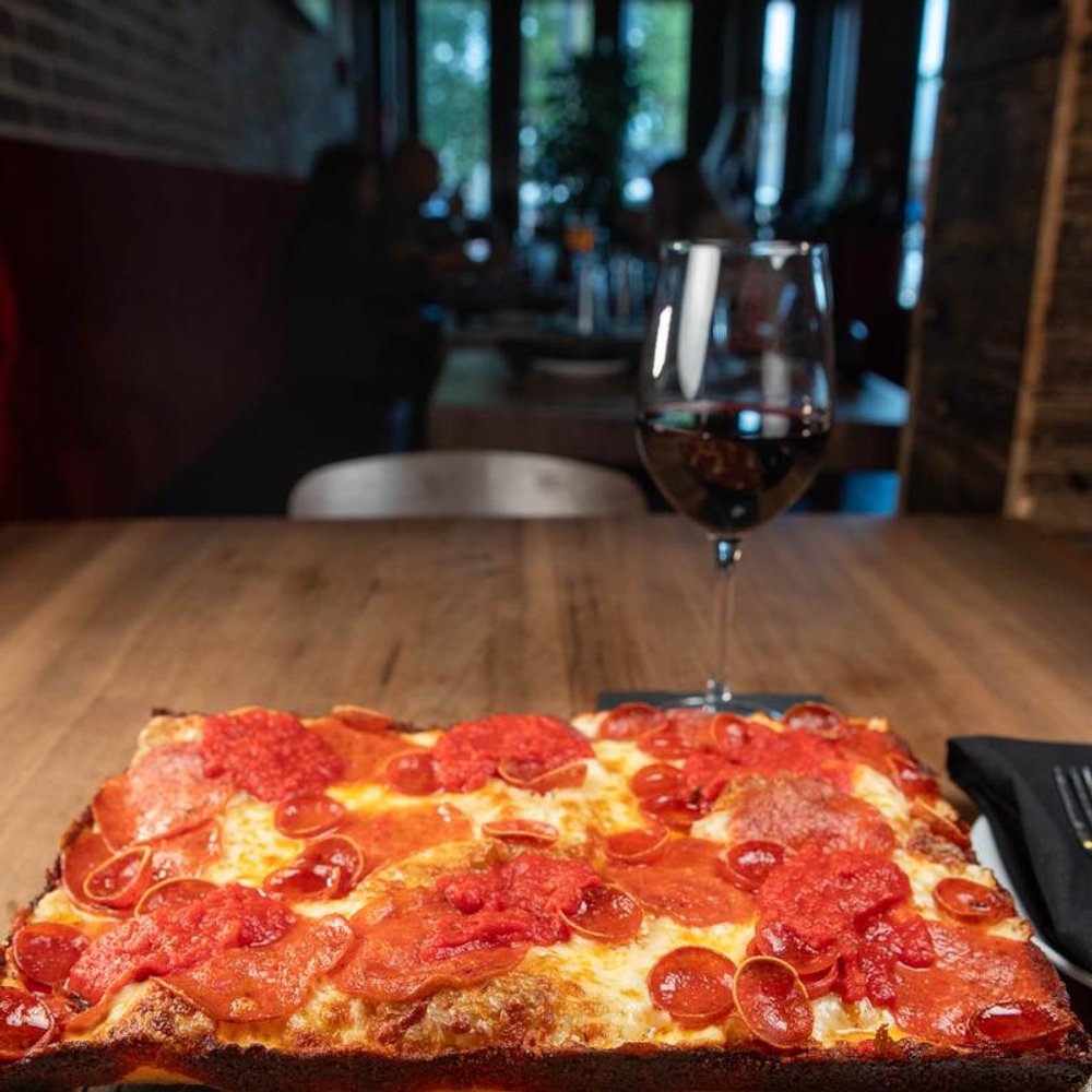 Square Pepperoni Pizza Served With A Glass Of Red Wine On A Table.