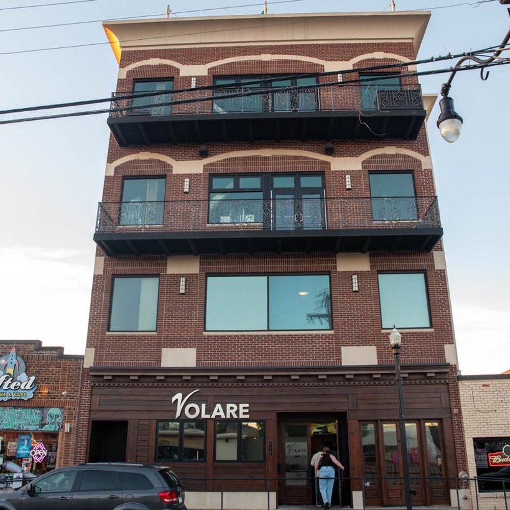 Storefront With Signage A Customer Walking In And A Parked Car.