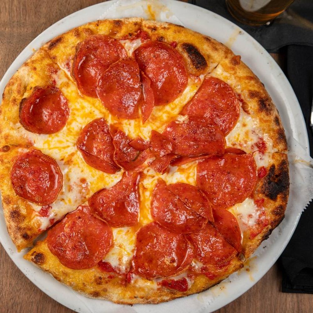 Top View Of A Pepperoni Pizza With Mozzarella And Red Sauce.