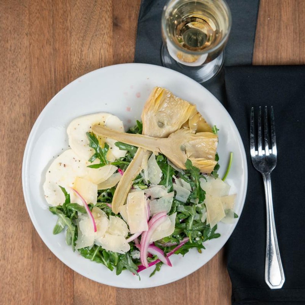 Top View Of Arugula Artichoke Salad Served With Sparkling Wine.