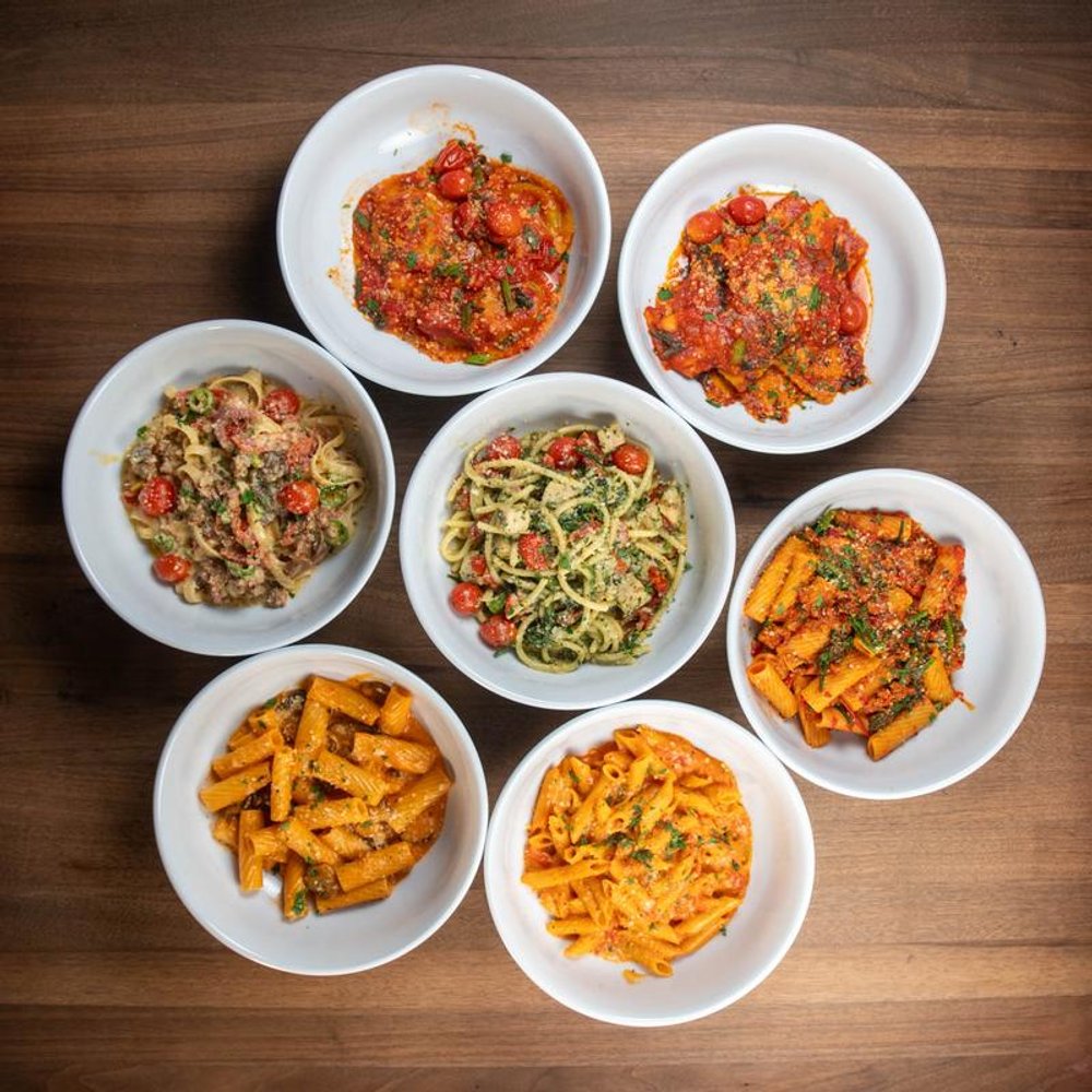 Top View Of Various Pasta Dishes On A Table.